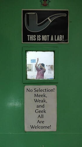 The entrance to the CUBE lab boldly displays the mandate of the program, while a CUBist is seen carrying out his work within the lab